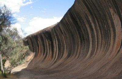 九、澳大利亚波浪岩 澳大利亚西部的波浪岩是天然岩层。由于它像高高的海浪因而得名。露出地面的部分占地几公顷，“浪潮”的部分岩石高约15米，长约110米。照片中显示的是罕见岩石墙。