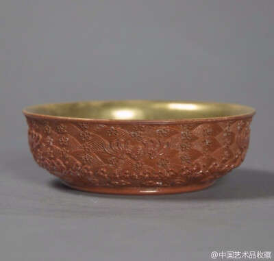 【 清乾隆 《仿雕漆红釉碗》 】高3.8cm，口径12.5cm，美国大都会艺术博物馆藏。 碗圆口微撇，矮弧壁，下承矮足，足底微凹中心浅挖圆形似玉璧底，六个小圆形支烧痕，无款。碗里满饰金彩。外壁仿雕漆工艺，近足处剔刻…