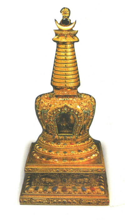 清代流传下来的几件典礼御用金器，器形都较大，而且黄金及珠宝用量都相当多，可以说史无前例。这件镶嵌松石的藏文金塔就是其中之一，它高80厘米，重29258.6克