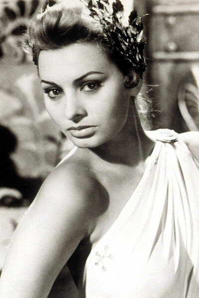 索菲亚-罗兰Sophia Loren(1934-)在1958年的《云雨夜未央》中穿着米色风衣绑着桃红色头巾的造型，1955年出席戛纳电影节时穿着雪纺公主裙搭配皮草披肩与华贵项链的造型。