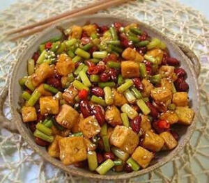 宫爆豆腐  豆腐、花生米1两、辣椒6个、大蒜6 瓣、青蒜3棵、糖、盐、番茄酱  1）把豆腐切成2厘米的小块，5成热 的油炸至金黄色出锅，沥干油待用。  2）花生米用凉水洗净泡一会儿包去 红衣，青蒜切花生米大小的段。  3）2勺糖1勺醋2勺番茄酱2勺水1勺 酱油调成汁待用。  4）锅中留少些底油，一定要凉油， 把辣椒和花生米同时放进锅里慢炒， 火要中火，以免把花生米炸糊，要不 停的翻炒至金黄色，把豆腐放进锅中 炒几下，倒入调好的汁翻炒，上色， 放青蒜，盐再炒几下就可以关火出锅 了。  这盘菜，是素的宫爆鸡丁，具备宫爆 鸡丁的色、香、味。