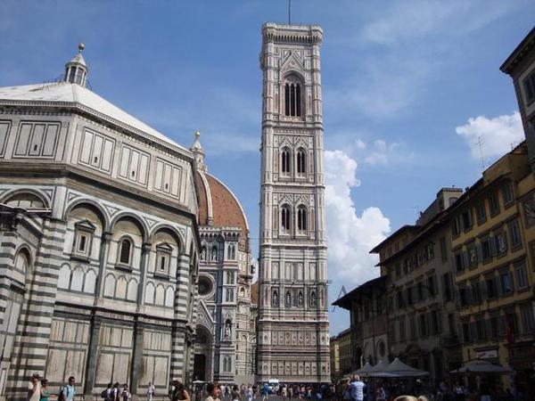 乔托钟楼位于圣母百花大教堂旁，面对佛罗伦萨圣若望洗礼，是著名画家乔托设计的，所以也称为乔托钟楼(Campanile di Giotto)。这座钟楼的样式属于哥特式，平面为周长14.45米的正方形，四角为高84.7米的四个多边形扶壁，四条垂直线又被四条水平线所分割，整座建筑布满了丰富的雕刻，和多种色彩的大理石镶嵌，其壮观的建筑和巧妙的设计博得了许多艺术爱好者的赞美。