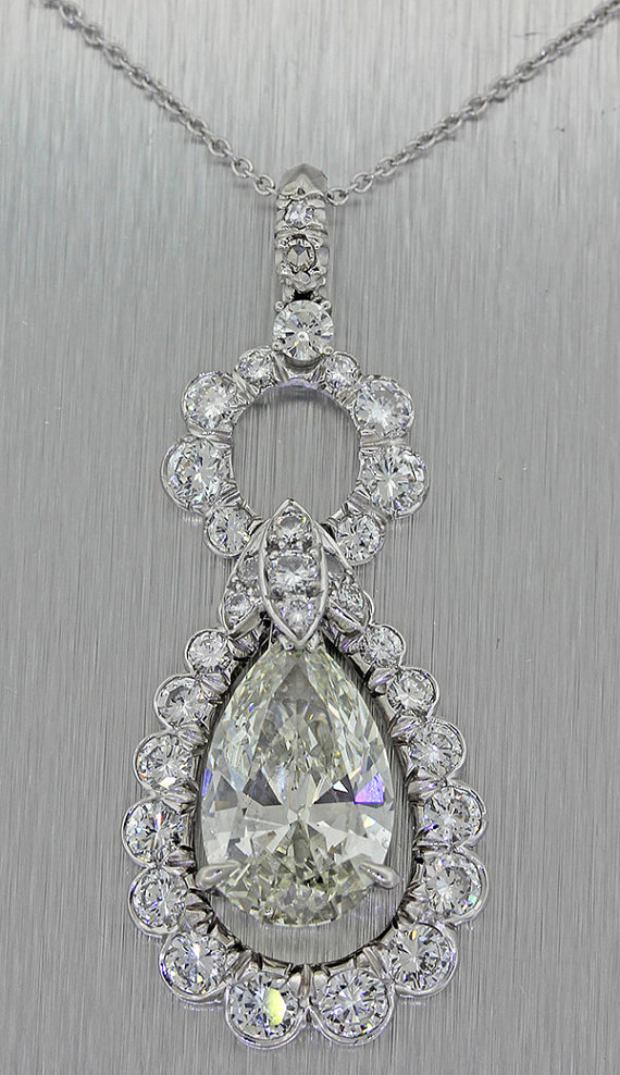 这是一个惊人的古董钻石和白金的装饰艺术风格的项链吊坠从1960年代这项链吊坠中心石是一个梨形切割天然钻石，颜色和净度VS2的共有5.05cts克拉重量。这条项链的建议零售价是143400美元，是由EGS；在世界上最著名的钻石分级机构之一。这条项链的钻石是充满火花和火焰的照片不能捕捉！