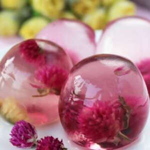 【DIY创意果冻水晶球】 用料: 鸭蛋4个、白凉粉30克、水200克、千日红适量、白糖适量。1. 鸭蛋底下用小刀通一通，倒出蛋液。2. 将蛋壳彻底冼净晾干备用，还要找个固定的东西，我拿出了冰箱里放蛋的架子。3. 将千日红用沸水冲开。4. 锅里水加热，放入适量白糖融化开。5. 加入适量白凉粉用筷子搅匀关火。6. 将泡好的千日红塞进蛋壳。 7. 将凉粉液倒入蛋壳。8. 等冷却后象剥蛋一样剥壳即可。9. 非常漂亮的一款甜品哦！