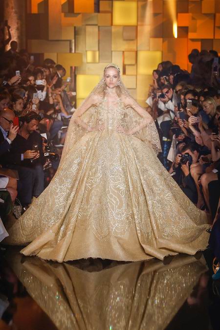 Elie Saab Fall Couture 2015。艾莉·萨博2015秋冬巴黎时装周高级定制发布。作为高级定制时装中最华丽的篇章，Elie Saab存在的意义与潮流无关，完全是为了造梦存在。总有人说审美疲劳之类，但得承认Elie Saab高定是所有黎巴嫩品牌中做工最精细也是当之无愧最漂亮最有质感的仙裙。本季Elie Saab的梦境极尽奢华，金碧辉煌。所有花朵都以最张扬梦幻的形式刺绣盛开，美，即是她们最强有力的武器。