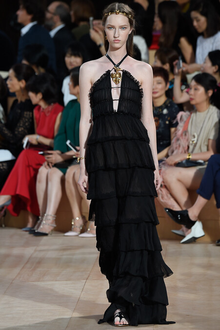 Valentino Fall 2015 Haute Couture。华伦天奴2015秋冬时装周高级定制发布。自1960年品牌创立，Valentino 已经牵手这座古老而神秘城市走过五十余载。本季选址在罗马人民广场，为此次大秀增添了一份怀古颂今的氛围。垂直而修长的线条一直都是Valentino最爱用来刻画庄重华贵造型的手法，教士袍与斗篷的简约设计强有力的刻画出罗马的神韵，又透露出古老世界中罗马战士的身影。瑰丽的锦缎与丝绒搭配华丽的镶边，奢华呼之欲出。象征着罗马权力与繁荣的雄鹰图案出现于礼服之上，为肃穆与庄严增添了一丝傲然于世的尊贵。