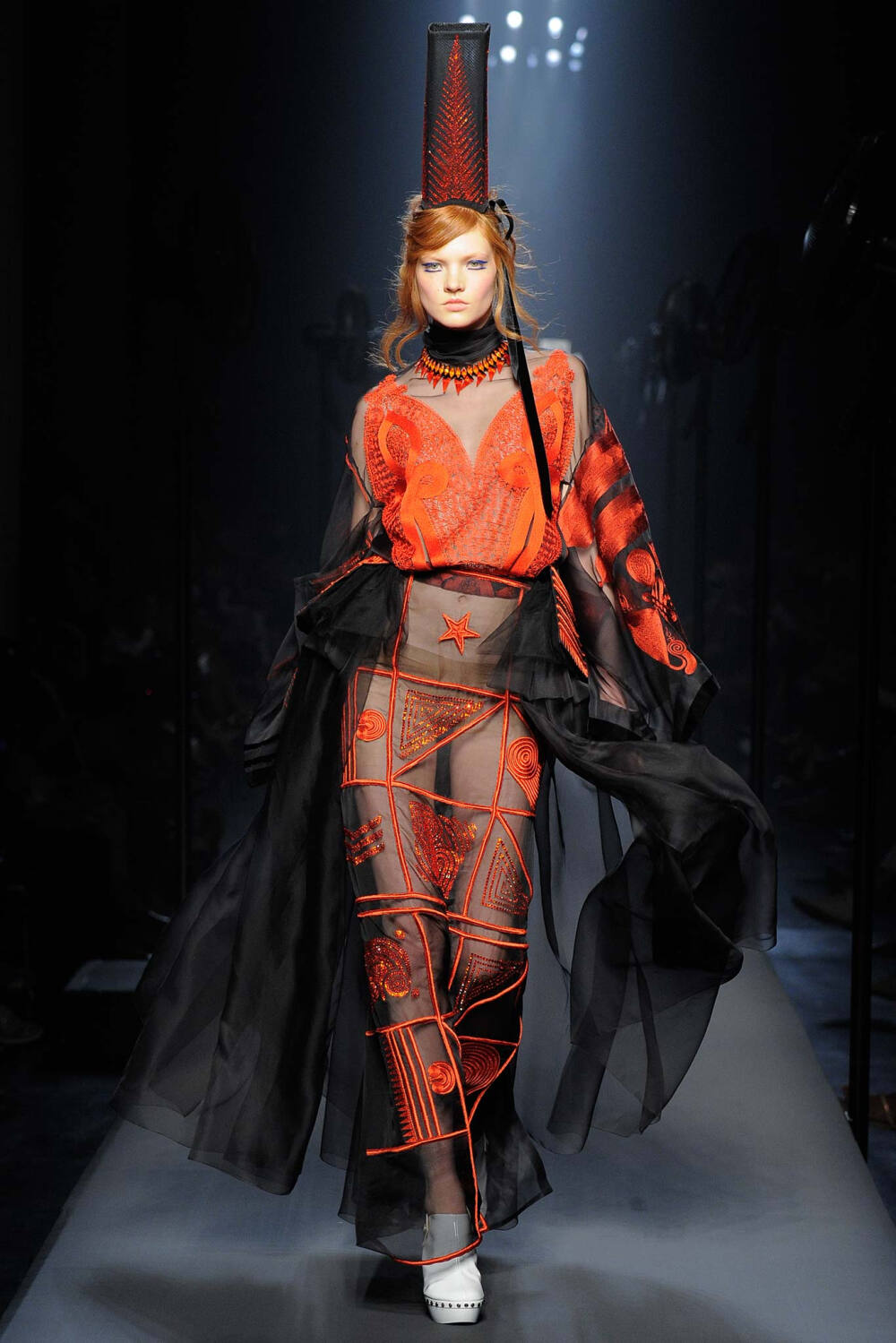 Jean Paul Gaultier Fall 2015 Couture。让·保罗·高缇耶2015秋冬高级定制时装周。本季灵感源于法国布列塔尼 (Brittany) 地区，这里绚烂多姿的民族服饰为高缇耶开启了一场航海旅程。“条纹”则是贯穿始终。开场的海军条纹直入主题，迸发出畅快呼吸的精神气，而这又不仅仅是一场旅行，更似一局盛大的聚会，狂欢的Party。黑色的主调也不觉单一，多色的火焰式花纹刺绣雕琢着民俗图腾，在裙摆、头饰上绘出历史的传说，极尽奢华，不可小觑的力量从海浪中款款而来。