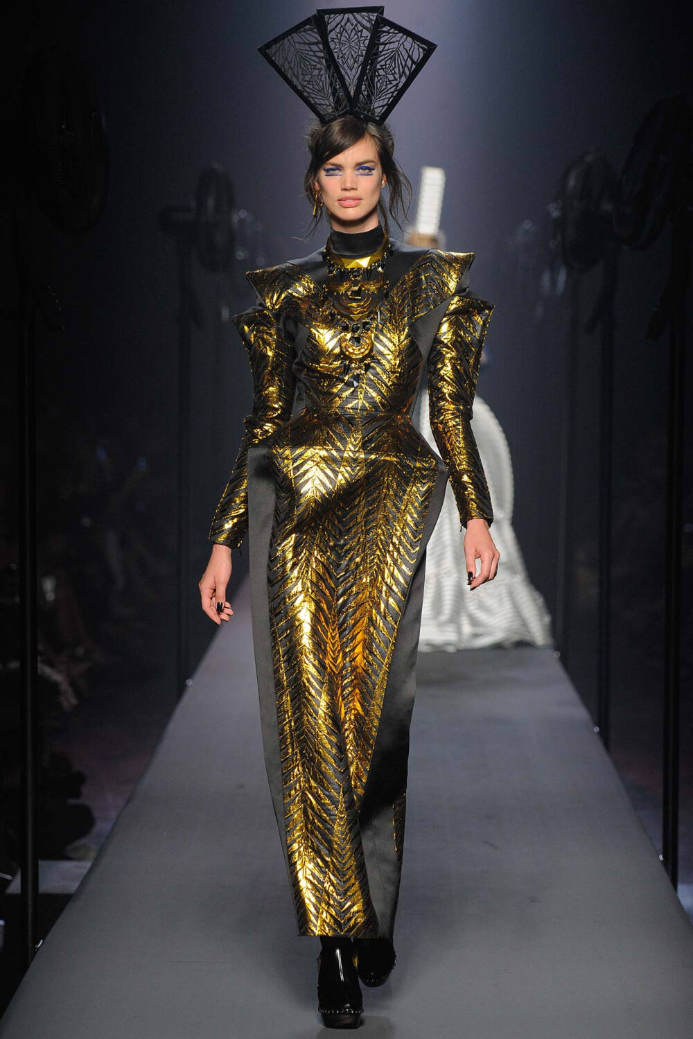 Jean Paul Gaultier Fall 2015 Couture。让·保罗·高缇耶2015秋冬高级定制时装周。本季灵感源于法国布列塔尼 (Brittany) 地区，这里绚烂多姿的民族服饰为高缇耶开启了一场航海旅程。“条纹”则是贯穿始终。开场的海军条纹直入主题，迸发出畅快呼吸的精神气，而这又不仅仅是一场旅行，更似一局盛大的聚会，狂欢的Party。黑色的主调也不觉单一，多色的火焰式花纹刺绣雕琢着民俗图腾，在裙摆、头饰上绘出历史的传说，极尽奢华，不可小觑的力量从海浪中款款而来。