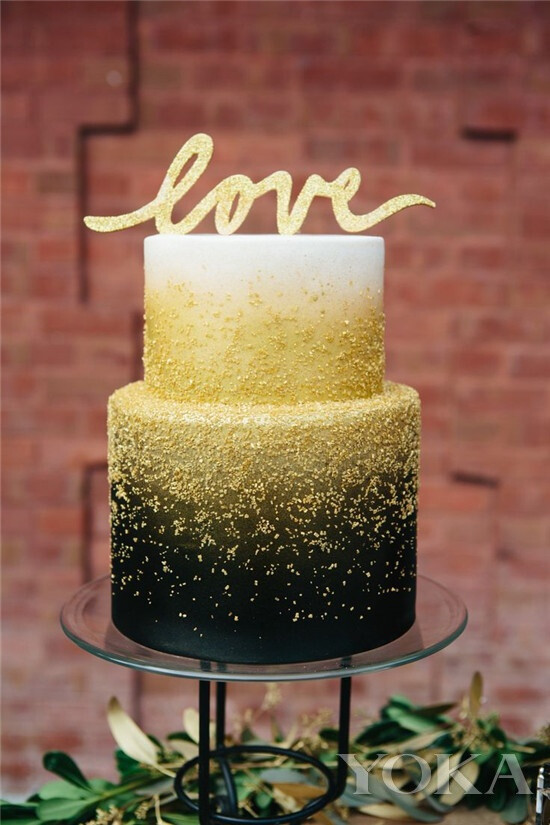 【镶金婚礼蛋糕】 双层蛋糕，由上至下呈现出白色向黑色的渐变，中间部分用金色素材搭配，让整款蛋糕看起来非常高贵奢华。如果想在婚礼当天大走土豪风，我想一只镶金蛋糕必不可少。