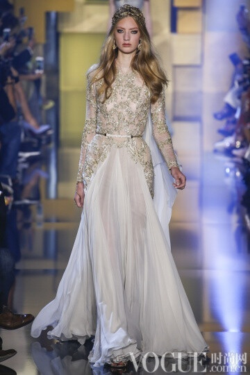 elie Saab 2015秋冬高级定E制发布秀 这次Saab的系列与以往不同的是减轻了装饰的分量，而意境也更为纯真，而少了妖娆。最新鲜的礼服中有一件搭配低跟天鹅绒凉鞋，下摆漫不经心地高于脚踝几吋。另一个给人惊喜的轮廓…