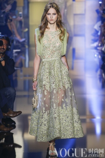 elie Saab 2015秋冬高级定E制发布秀 这次Saab的系列与以往不同的是减轻了装饰的分量，而意境也更为纯真，而少了妖娆。最新鲜的礼服中有一件搭配低跟天鹅绒凉鞋，下摆漫不经心地高于脚踝几吋。另一个给人惊喜的轮廓是直筒衫搭配窄腿长裤和无袖外套，其肩部装饰着环形的皮草。