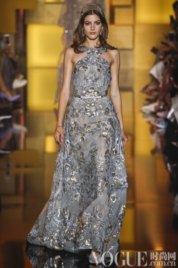 elie Saab 2015秋冬高级定E制发布秀 这次Saab的系列与以往不同的是减轻了装饰的分量，而意境也更为纯真，而少了妖娆。最新鲜的礼服中有一件搭配低跟天鹅绒凉鞋，下摆漫不经心地高于脚踝几吋。另一个给人惊喜的轮廓是直筒衫搭配窄腿长裤和无袖外套，其肩部装饰着环形的皮草。