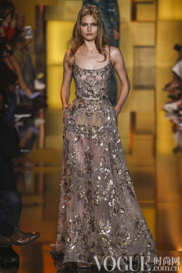 elie Saab 2015秋冬高级定E制发布秀 这次Saab的系列与以往不同的是减轻了装饰的分量，而意境也更为纯真，而少了妖娆。最新鲜的礼服中有一件搭配低跟天鹅绒凉鞋，下摆漫不经心地高于脚踝几吋。另一个给人惊喜的轮廓是直筒衫搭配窄腿长裤和无袖外套，其肩部装饰着环形的皮草。