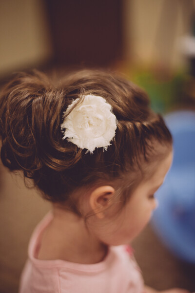 flower girl hair updo, braided twist into an upside down ponytail with a little fabric flower. such a cute miniature bridesmaid!