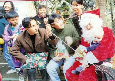 1991年12月18日，张国荣与周星驰代表《家有喜事》剧组赴香港特殊儿童中心探望缓智儿童，为孩子们送圣诞礼物。