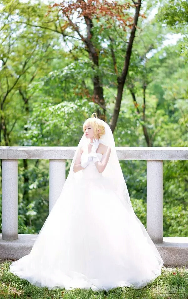 极致唯美婚纱saber cos saber身着纯白的婚纱，手捧蓝白娇艳的花朵，几乎可以成为完美的治愈笑容，直戳你我春心！韩国螺旋猫COS团体的tomia活生生再现了saber的完美身影。