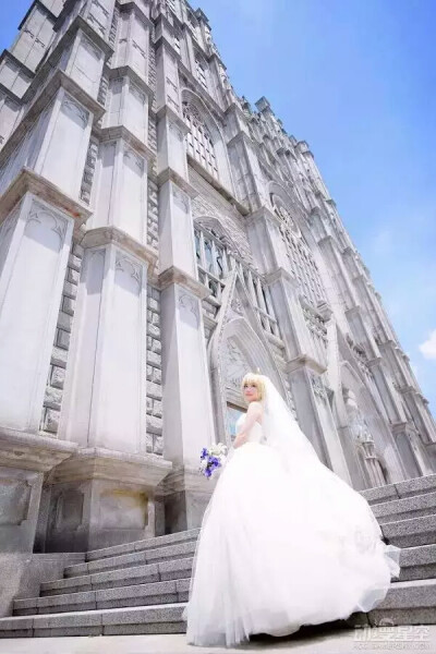 极致唯美婚纱saber cos saber身着纯白的婚纱，手捧蓝白娇艳的花朵，几乎可以成为完美的治愈笑容，直戳你我春心！韩国螺旋猫COS团体的tomia活生生再现了saber的完美身影。