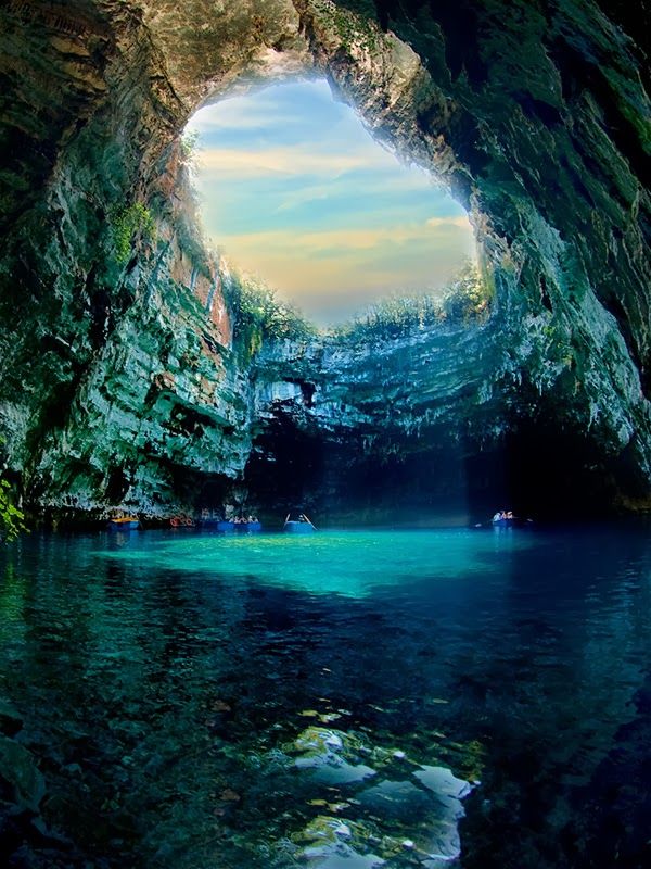 Melissani Cave, Kefalonia, Greece。希腊梅利萨尼洞，希腊语中的Melissani意为女神的洞穴，位于希腊凯法利尼亚岛东海岸，距离Sami镇约2公里处。被森林包围下的梅利萨尼洞在1951年首次被发现，并从1963年起开始开放。整个山洞长达100米，由两个遍布湖水的大洞和中间一个小岛组成，里边的洞穴拱顶上挂满了众多的钟乳石和石笋；而外面的大洞顶部则有一个椭圆形的大开口，当阳光照射下来时，光线会撞击在群青色的水面上，再变成蓝色的光芒反射到洞穴周边，所以参观洞穴的最佳时间是在一个阳光明媚的中午。