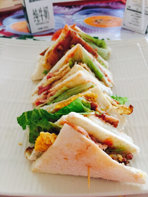 #窝里蹲速食# 用料：培根，切边面包片，芝士片，鸡蛋，生菜，西红柿，沙拉酱，番茄酱。夹起来之后从中间切开，垂直摆放然后用牙签插起来～不仅要美味还要健康和好看。速食主义健康也很重要！