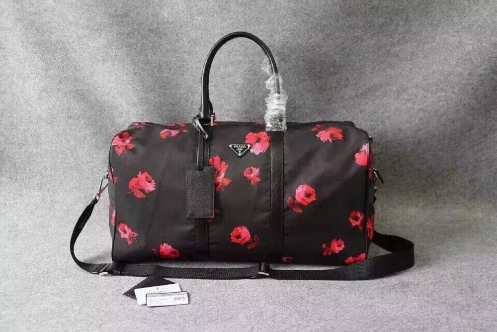 【prada】V20S 【尺寸】W54cm×H37cm×D23cm 【产品介绍】新面料搭配，搭配独特玫瑰花面料..超大斜挎旅行袋，黑色玫瑰%龙防水手提包，呖色五金。拉链开口，底部设有保护脚钉，可拆卸式斜挎肩