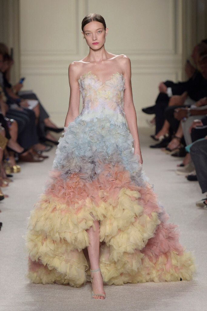 Marchesa Spring 2016 Ready to Wear 。玛切萨2016纽约时装周高级成衣系列。本季运用花朵的元素，黑色的镂空轻纱配紧绷的丝带诠释一种阴郁却又唯美的氛围。大片花朵的装饰更是代表了女性浪漫轻柔的气质，层层包裹身体的轻纱飘逸又服帖，场面好似不同风情的花仙子在从中嬉戏。