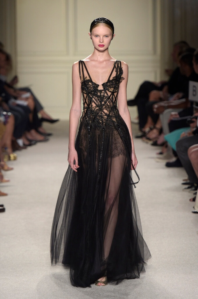 Marchesa Spring 2016 Ready to Wear 。玛切萨2016纽约时装周高级成衣系列。本季运用花朵的元素，黑色的镂空轻纱配紧绷的丝带诠释一种阴郁却又唯美的氛围。大片花朵的装饰更是代表了女性浪漫轻柔的气质，层层包裹身体的轻纱飘逸又服帖，场面好似不同风情的花仙子在从中嬉戏。