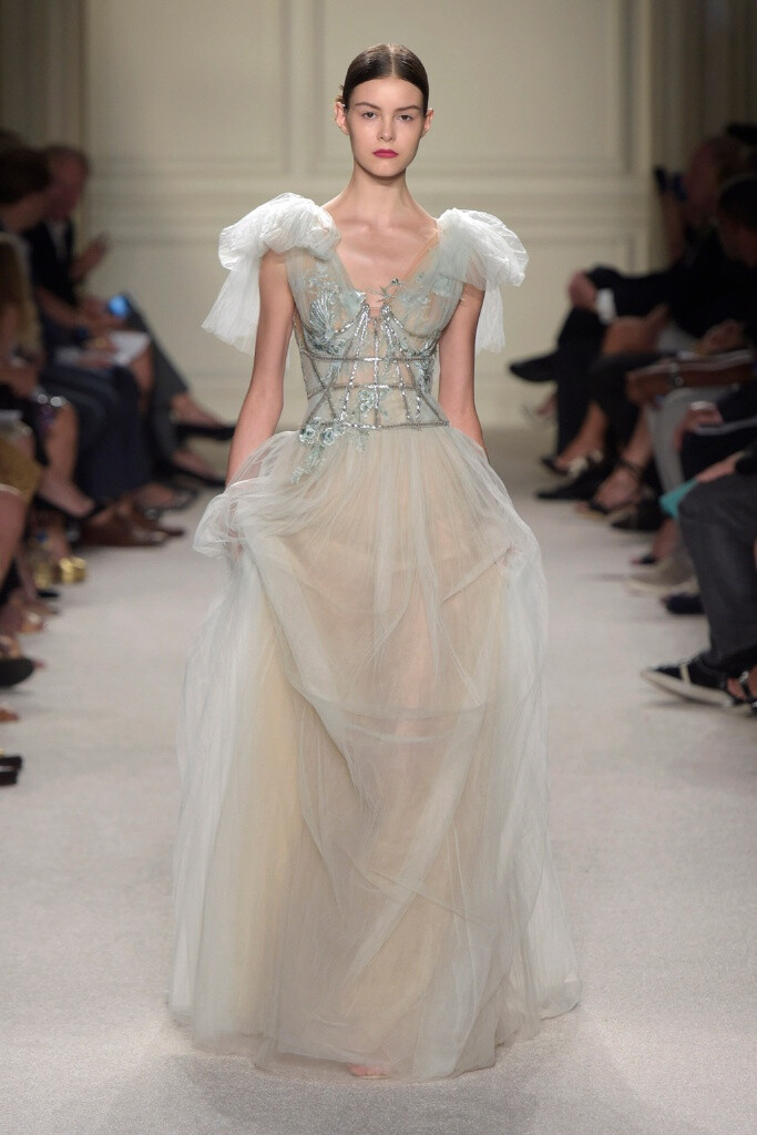 Marchesa Spring 2016 Ready to Wear 。玛切萨2016纽约时装周高级成衣系列。本季运用花朵的元素，黑色的镂空轻纱配紧绷的丝带诠释一种阴郁却又唯美的氛围。大片花朵的装饰更是代表了女性浪漫轻柔的气质，层层包裹身体的轻纱飘逸又服帖，场面好似不同风情的花仙子在从中嬉戏。