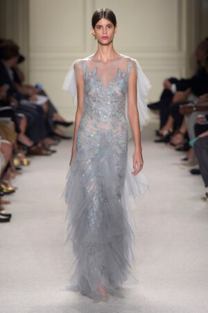 Marchesa Spring 2016 Ready to Wear 。玛切萨2016纽约时装周高级成衣系列。本季运用花朵的元素，黑色的镂空轻纱配紧绷的丝带诠释一种阴郁却又唯美的氛围。大片花朵的装饰更是代表了女性浪漫轻柔的气质，层层包裹身体的轻纱飘逸又服帖，场面好似不同风情的花仙子在从中嬉戏。