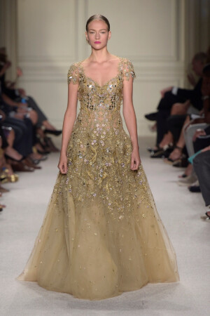 Marchesa Spring 2016 Ready to Wear 。玛切萨2016纽约时装周高级成衣系列。本季运用花朵的元素，黑色的镂空轻纱配紧绷的丝带诠释一种阴郁却又唯美的氛围。大片花朵的装饰更是代表了女性浪漫轻柔的气质，层层包裹身体的轻纱飘逸又服帖，场面好似不同风情的花仙子在从中嬉戏。