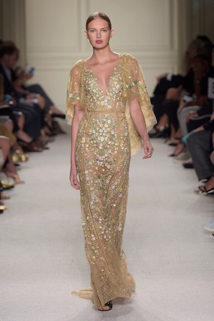 Marchesa Spring 2016 Ready to Wear 。玛切萨2016纽约时装周高级成衣系列。本季运用花朵的元素，黑色的镂空轻纱配紧绷的丝带诠释一种阴郁却又唯美的氛围。大片花朵的装饰更是代表了女性浪漫轻柔的气质，层层包裹身体的轻纱飘逸又服帖，场面好似不同风情的花仙子在从中嬉戏。