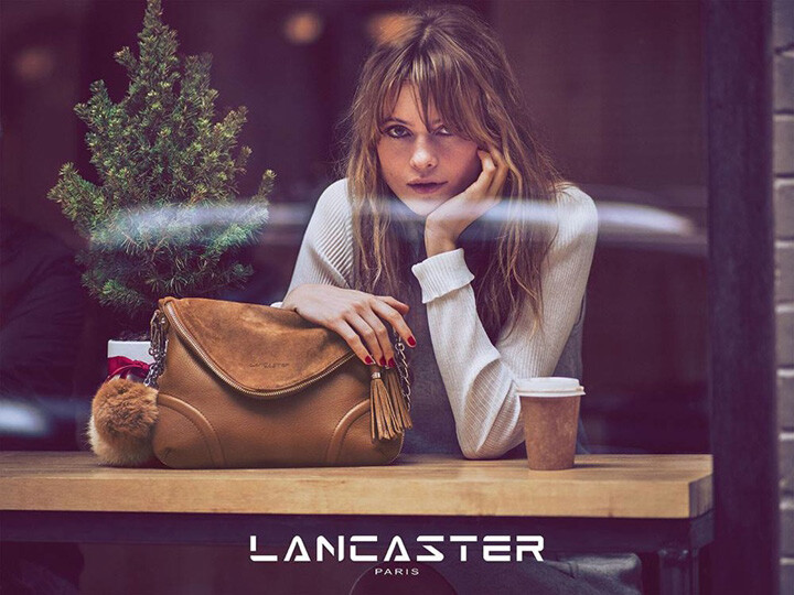 法国知名皮具品牌 Lancaster（兰嘉丝汀）释出最新2015圣诞系列广告大片，维密天使超模 Behati Prinsloo（贝哈蒂·普林斯露）再度出镜代言，摄影师 Guy Aroch 执镜。贝哈蒂拿着扎着红色蝴蝶结的小盆圣诞树游走于城市各处