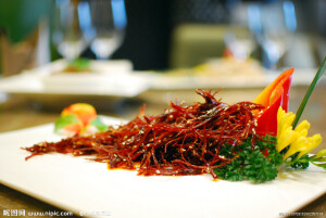 灯影牛肉   ：选黄牛后腿部净瘦肉，不沾生水，除去筋膜 ，修节 整齐，片成极薄的大张肉片。将肉片抹上炒热磨细的盐，卷成圆筒，放在竹筲箕内， 置通风处晾去血水。取晾好的牛肉片铺在竹筲箕背面，置木炭火上烤干水气，入笼蒸 半小时，再用刀将肉切成长一寸五，宽一寸的片子，重新入笼蒸半小时，取出晾冷。 菜油烧熟，加入生姜和花椒少许，油锅挪离火口。10分钟后，把渍锅再置火上，捞去 生姜、花椒。然后将牛肉片上均匀抹上糟汁下油锅炸，边炸边用铲轻轻搅动，待牛肉 片炸透，即将油锅挪离火口，捞出牛肉片。锅内留熟油，置火上加入五香粉、白糖、 辣椒面、花椒面，放入牛肉片炒匀起锅，加味精、熟芝麻油，调拌均匀，晾冷即成。