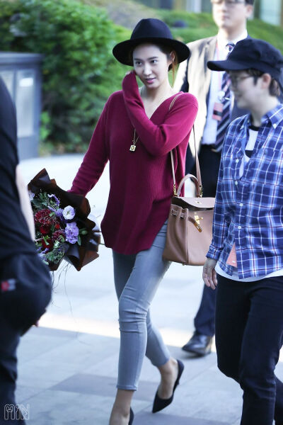 Yuri——紫红色宽松低领针织衫，搭配灰色紧身牛仔裤、尖高跟和棕色单肩包。。