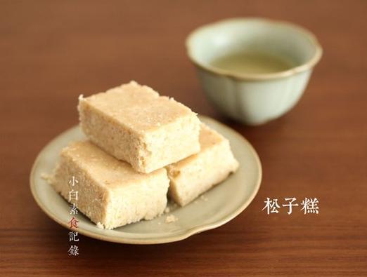 [甜品小吃(无需烘焙)----松子糕] 松子糕是江浙一带的传统茶点，以前吃过，入口即化，松子清香，正巧家里有别人送的松子，自己琢磨配方居然很成功。通常用来配茶的点心都是比较甜的，切成一小块一小块，别贪吃哦.做法原料都不复杂，而且不需要烤箱，松子也可以换成其他自己喜欢的坚果。以下是12块左右的分量糯米粉200g；松子仁50g；糖100g；水100g；香油20g