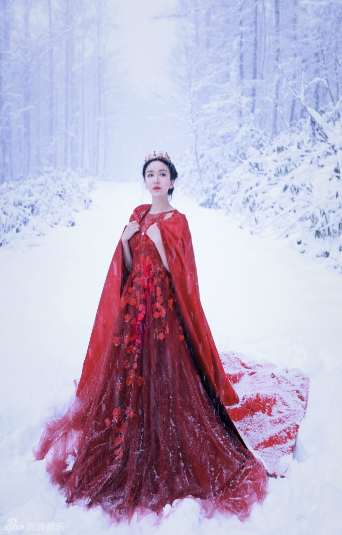 娄艺潇 曝光一组红衣圣诞大片——照片中娄艺潇长发盘起，身穿一袭红色镂空花朵长裙，置身于一片洁白的冰雪世界里，宛若仙子