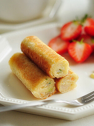   【鲜虾吐司卷】  1.鲜虾去皮去泥肠洗净剁碎(也可剁成泥)，葱姜切末 2.加入盐、白胡椒、料酒、鸡精、香油、蛋清调整至略稀的状态 3.吐司片切去四边；用擀面杖擀压，尾端要压得更薄些便于最后沾紧 3.涂抹鲜虾馅 4.小心卷起，收口处要少一些馅料 5.中火少油煎至金黄 6.出锅用厨房纸巾吸去多余油脂