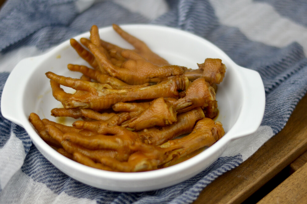 【20道解馋小食】电饭锅版卤鸡爪：鸡爪洗净用滚汆一遍，捞起沥干后，倒入电饭锅中，加入2勺老抽，3勺生抽，2勺糖，2勺料酒，香叶，8角，适量盐，加入没过鸡爪，入电饭锅，打开煲粥或煲汤功能即可