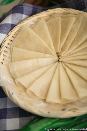 春饼 材料：中筋面粉，水，油，蒸锅 1.准备烫面面团：两杯面粉倒入大盆；取一又五分之一杯冷水，将冷水的三分之二用微波炉加热到80摄氏度以上，倒入面粉中，用筷子立刻搅匀面粉，面粉会呈棉絮状。再加剩下的三分之一冷水，待面团冷却到不烫，用手把面团揉到三光并且有韧劲，揉5-10分钟就够。用湿布盖住醒半小时左右。 2.擀皮：面团揉成长条，切成小剂子，每个剂子擀开成越1mm薄的圆形。擀好的面皮刷上油，一个摞一个，每十张饼皮一盘，顶上搭一块薄湿布。 4.蒸饼皮：蒸锅水烧开，放入一盘十片饼皮，大火蒸5-8分钟。