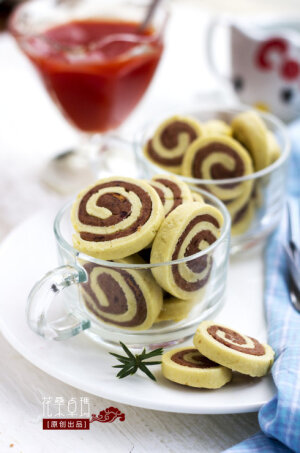 【豆沙圈圈饼】 用料： 原味面团：低筋面粉120g，鸡蛋40g，黄油40g，糖粉25g  豆沙面团：豆沙150g，低筋面粉40g，糖粉10g 烤箱：温度165度，时间20分钟   做法： 1、备齐所需食材； 2、黄油常温软化后，与糖粉混合用手动打蛋器搅打至混合均匀； 3、加入蛋液继续搅打至混合； 4、筛入低筋面粉，用刮刀拌和均匀成面团； 5、用保鲜膜包裹面团静置约10分钟左右； 6、豆沙与糖粉，低筋面粉拌和均匀，成豆沙面团儿； 7、分别将两种面团擀成约0.2-0.3cm厚的面片，边缘部分切整齐后，表面刷一层蛋液，重叠放置后从一边卷起成卷卷状； 8、卷好的面团，用保鲜膜包裹，放入冰箱冷冻20分钟； 9、取出后切片，放置在烤盘上，烤箱温度165度，时间20分钟，预热后放入烤盘即可。