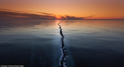 俄罗斯的贝加尔湖（Baikal Lake）是世界上最大的淡水湖。近日，俄罗斯摄影师Alexey Trofimov捕捉到了冰冻的贝加尔湖湖面上数百米长的冰裂，裂缝仿佛绵延至天际，映衬在夕阳中，显得美妙绝伦。