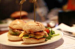 「自制小汉堡」材料：鸡蛋1个，土司两片，应季水果1个，生菜1片，火腿肠适量，花生酱适量。
步骤：1. 将鸡蛋煮熟，切成片，厚薄适中。
2. 将吐司硬边切掉，用模具压成若干片小圆面包片。
3. 将水果切片，火腿肠切片。
4. 土司片放入平底锅中烤一下，使之温热更松软，其它材料也可放入平底锅中加热。
5. 用牙签将上述材料串起来即可，顺序依次为：小面包片、花生酱、生菜、火腿肠片、水果片、鸡蛋片、小面包片。
tips:1.小汉堡配上一碗牛奶燕麦粥或牛奶红豆粥，营养更丰富。
2.面包片也可换成薄的馒头片。
3.要是给小孩吃的话，注意小心不要让小家伙们被牙签戳到嘴哦。