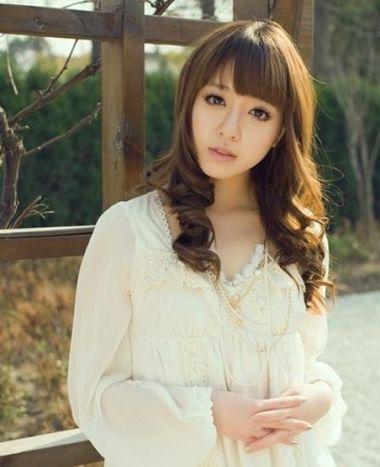 在2016年鹅蛋脸女生梳理一款齐刘海厚薄适中的齐刘海，披肩中长发从肩部下方将直发烫成中卷螺旋卷，披散在肩部，将有些宽的脸庞修饰成精致的瓜子脸，演绎最靓丽的优雅魅力女生。