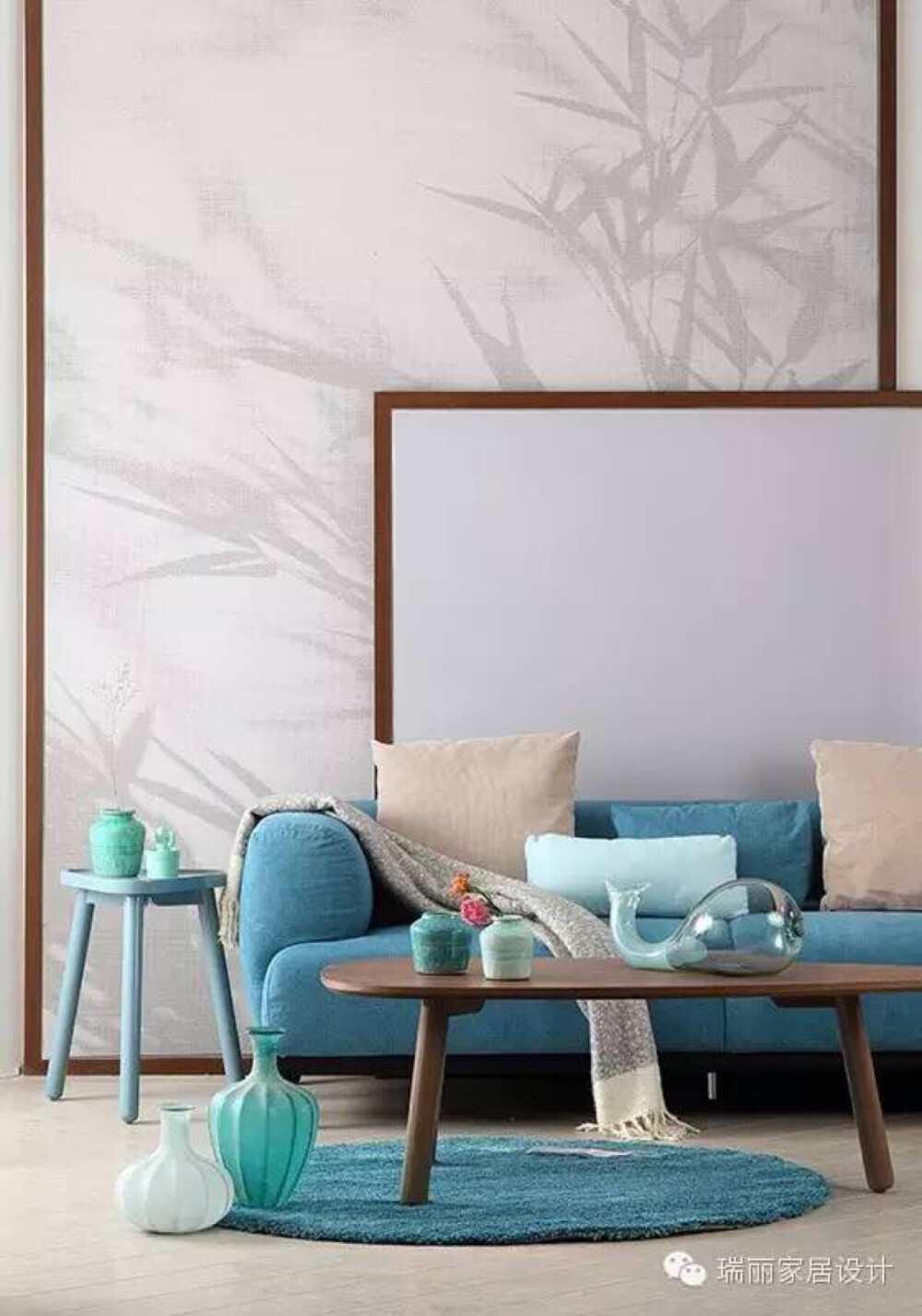 象征君子的竹子图案做背景墙是中式元素的巧妙运用，通过不同色度的灰色搭配更有韵味。白色和木色在背景墙上的运用打破了图案的单一，湖蓝色沙发、地毯与浅蓝色边几及各种蓝色花器形成呼应，一抹湖蓝恰到好处地体现了年轻感。