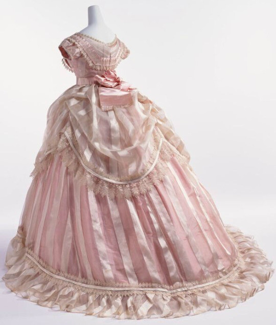 Im madly in love with this 1865 evening gown in striped silk taffeta
with lace trimmed striped sheer overlay