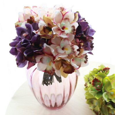 把束洋蕙兰仿真花摆件，花形优美，色彩丰富，栩栩如生，配上复古玻璃花瓶，带来一丝唯美的气息。
