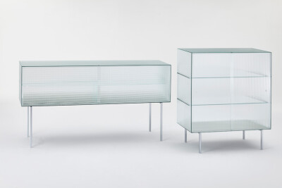 Piero Lissoni 在米兰家具展推出了 Glas Italia 的新品 Commodore 玻璃家具作品采用条格印花玻璃，轨道上安有推拉门设计，可以展现内部收藏。设计简单明了，高贵典雅，表达出一种纯粹的视觉效果。