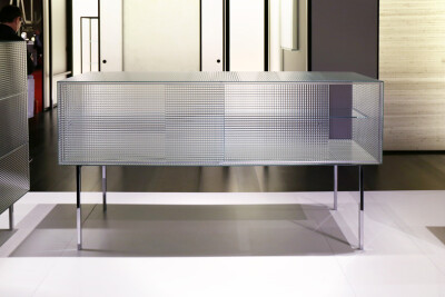 Piero Lissoni 在米兰家具展推出了 Glas Italia 的新品 Commodore 玻璃家具作品采用条格印花玻璃，轨道上安有推拉门设计，可以展现内部收藏。设计简单明了，高贵典雅，表达出一种纯粹的视觉效果。