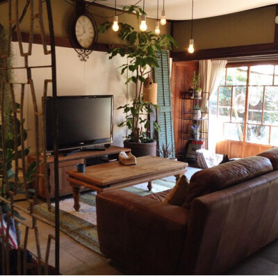 日式风格 深棕色沙发和隔断 一片落地窗 简单复古的几站照明灯使整个客厅异常和谐