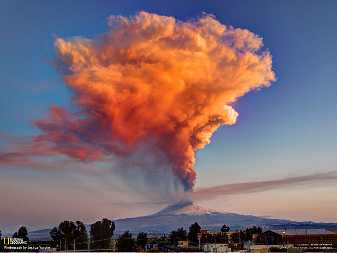 埃特纳火山新年第一次喷发，阳光照在火山灰云上呈现出美丽鲜艳的色彩