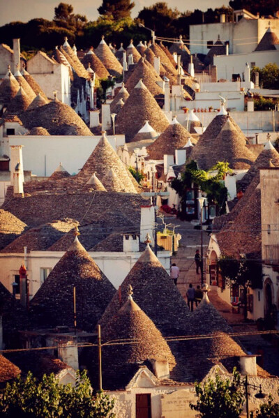 Alberobello, Bari, Puglia, Italy。阿尔贝罗贝洛是意大利普利亚大区巴里省的一个小城，城内圆锥形房顶的特鲁洛建筑(trullo,复数为trulli)世界知名，1996年被联合国教科文组织列为世界文化遗产。特鲁洛的特色是墙壁…